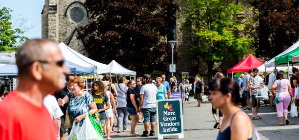 Market outside in the summer with vendors and visitors